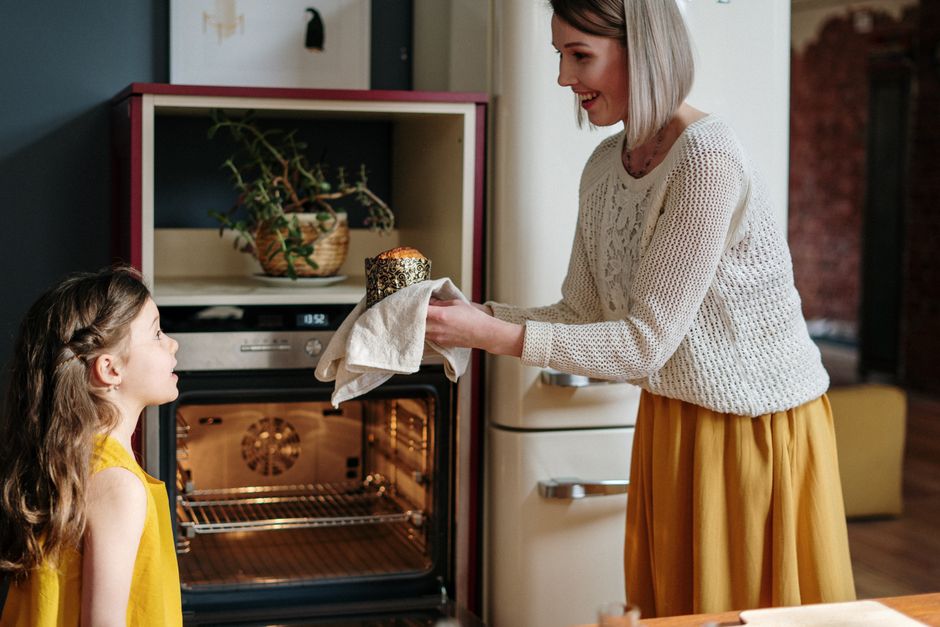 Close-up image of a stainless steel oven with a digital clock displaying 19:32. The oven features a sleek, modern design with control knobs on the front panel. The surface appears clean and polished,